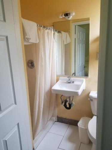 
a bathroom with a sink, toilet and shower at Budget Inn Hollywood in Los Angeles
