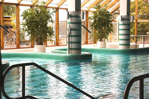 a swimming pool with pillars in a building at Summer Hotel Vuorilinna in Savonlinna