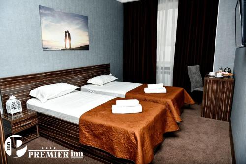 a hotel room with two beds with towels on them at Premier Inn Astana in Astana