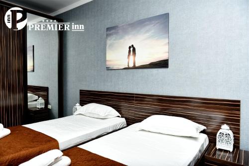 two beds in a room with a picture on the wall at Premier Inn Astana in Astana