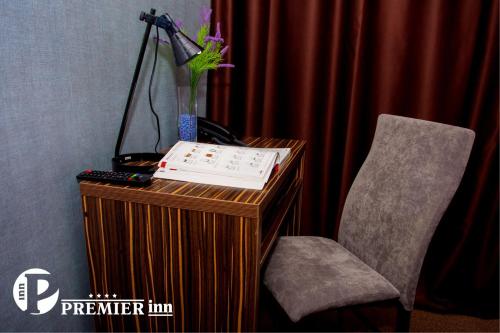 a desk with a chair and a vase of flowers at Premier Inn Astana in Astana