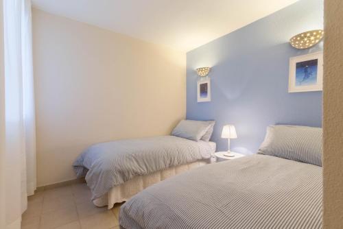 two beds in a small room with blue walls at Villa Luna - Vacanza a Villasimius vicino alle spiagge più rinomate della costa in Villasimius