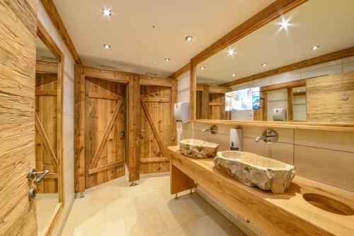 baño con 2 lavabos y paredes de madera en Metzgerei Gasthof Oberhauser - Hotel zur Post, en Egling