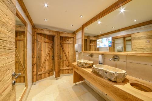 a bathroom with two sinks and wooden walls at Metzgerei Gasthof Oberhauser - Hotel zur Post in Egling