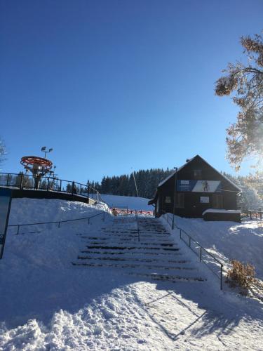 a snow covered path leading to a cabin in the snow at Penzion Na Solné stezce in Kašperské Hory