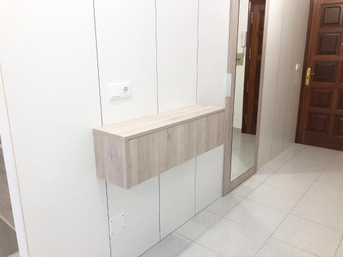 Baño blanco con lavabo y espejo en Pitelos Apartment, en Santiago de Compostela