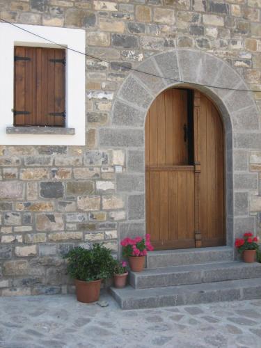 a stone building with two wooden doors and potted plants at Casa Magdalena Autural in Siresa