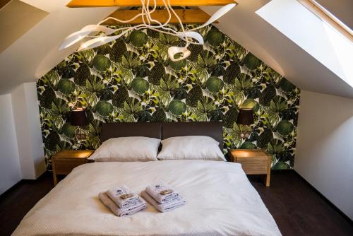 una camera da letto con un grande letto con due asciugamani di Wellness & Spa Boutique Hotel Villa Memories a Fryšták