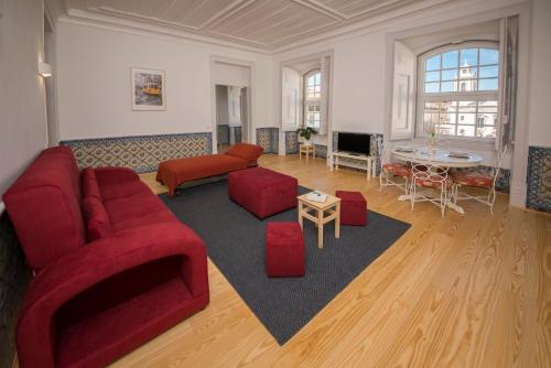 - un salon avec un canapé rouge et des fauteuils rouges dans l'établissement Luxurious Cais do Sodre - 4 bedrooms with amazing view, à Lisbonne