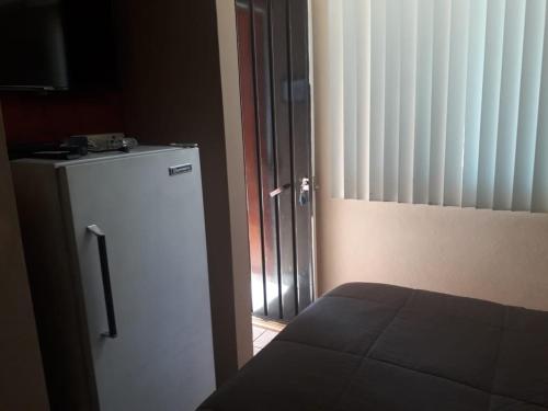a room with a refrigerator and a door with a window at Villa Paraiso in Emiliano Zapata