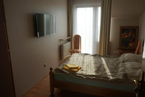 a bedroom with a bed with a television on the wall at Willa Joker in Krynica Morska