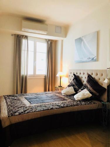 une chambre avec un grand lit avec une fenêtre dans l'établissement Ô Palais des Iles Two Bedroom Cannes, à Cannes