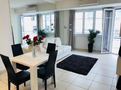 a living room with a table and a white couch at Ô Palais des Iles Two Bedroom Cannes in Cannes