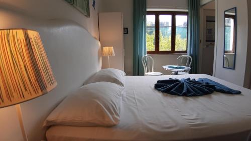 um quarto com uma cama branca e um roupão. em Lemon Town em Sorrento