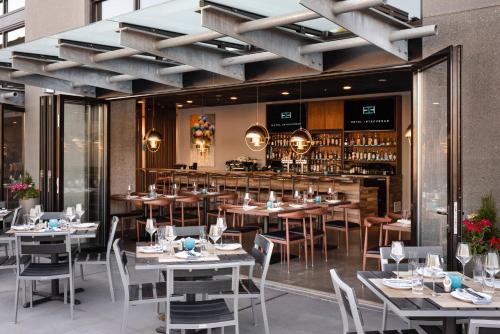 um restaurante com mesas e cadeiras e um bar em Hotel Interurban Seattle Airport SeaTac em Tukwila