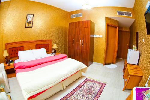 a bedroom with a large bed and a television at Arbella Boutique Hotel in Sharjah