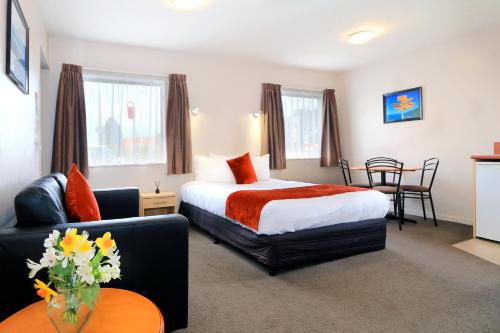 een hotelkamer met een bed en een bank bij Bella Vista Motel Invercargill in Invercargill