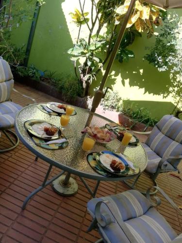 a glass table with plates of food on it on a patio at Hostal Doña Mercedes in Juayúa