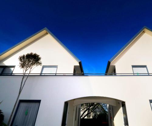 a white house with a blue sky behind it at Bella Vista Motel Invercargill in Invercargill