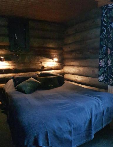 a bedroom with a bed with a wooden wall at Ylämaja - with a stunning view in Ruka