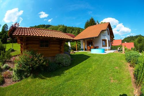 a small log cabin with a grass yard at Chata U Huberta in Trutnov