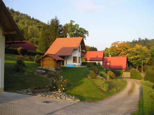 een huis met een oranje dak in een tuin bij Chata U Huberta in Trutnov