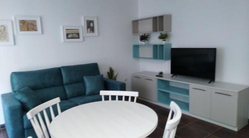 a living room with a couch and a table and a tv at San Cibrao,belleza y tranquilidad. in San Ciprián