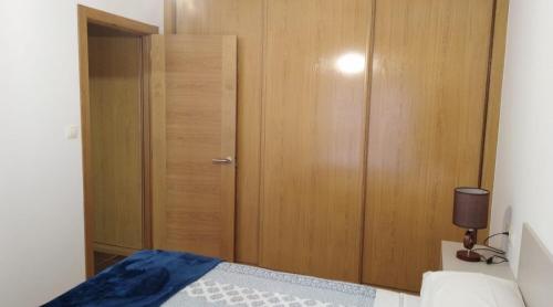 a bedroom with a wooden closet and a bed at San Cibrao,belleza y tranquilidad. in San Ciprián