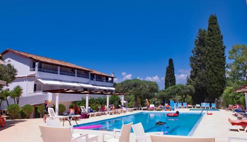 a pool at a resort with people sitting around it at Katia Beach Hotel in Kassiopi