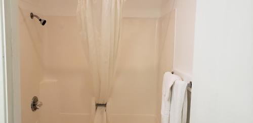 eine Dusche mit einem weißen Duschvorhang im Bad in der Unterkunft Pacific Inn in Crescent City