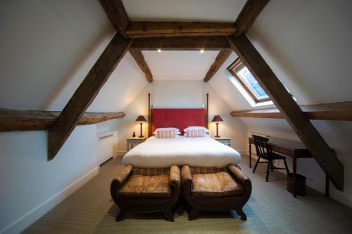 a attic bedroom with a bed and a desk at Cotswold House Hotel and Spa - "A Bespoke Hotel" in Chipping Campden