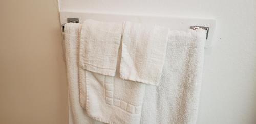 a group of white towels hanging on a towel rack at Pacific Inn in Crescent City