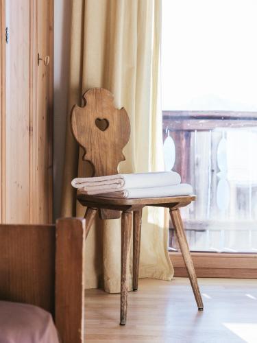 a wooden chair sitting in front of a window at Rifugio Graziani Hütte in San Vigilio Di Marebbe