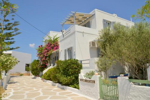 une maison blanche avec une clôture et des arbres dans l'établissement Studios Kymata, à Pollonia