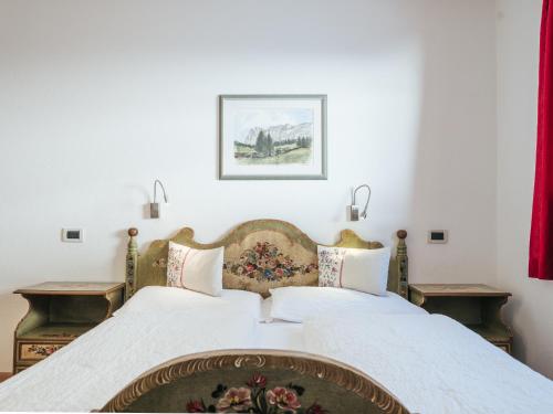 a bedroom with a large bed with two tables at Rifugio Graziani Hütte in San Vigilio Di Marebbe