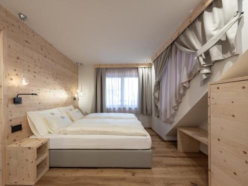 a bedroom with a large bed and a staircase at Rifugio Graziani Hütte in San Vigilio Di Marebbe