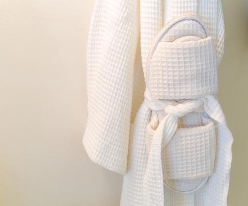 a white robe with a bow on a wall at Eleven Bahama House in Harbour Island