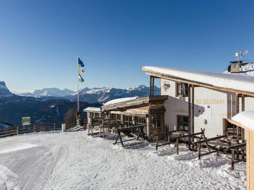 un lodge de esquí con una montaña cubierta de nieve en el fondo en Rifugio Graziani Hütte en San Vigilio Di Marebbe