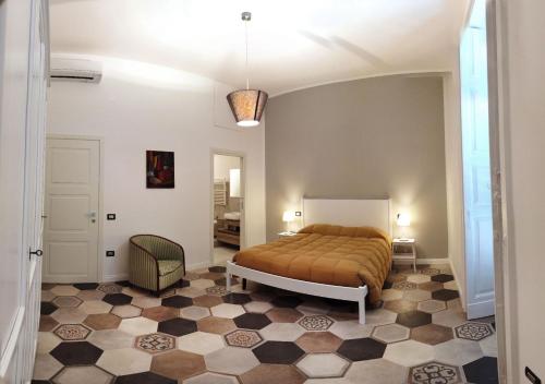 a bedroom with a bed and a checkered floor at Casa Tilde Bacoli in Bacoli