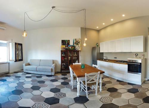 a kitchen with a table and a couch at Casa Tilde Bacoli in Bacoli