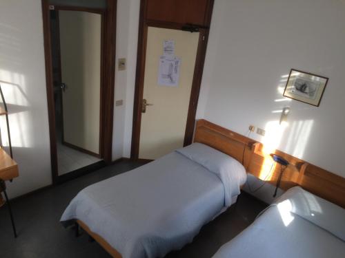 a hospital room with two beds and a mirror at Casa per ferie Al Centro in Belluno