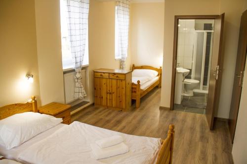 ein Schlafzimmer mit einem Bett und ein Badezimmer mit einem WC in der Unterkunft Pizzerie Jasany in Nový Šaldorf