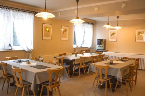 un comedor con mesas, sillas y ventanas en Pizzerie Jasany en Nový Šaldorf