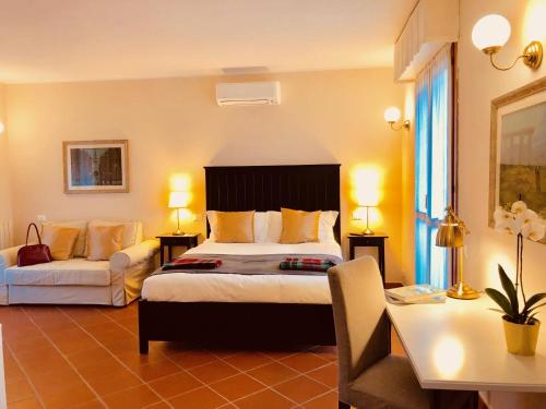 una camera d'albergo con letto, divano e scrivania di Casa Ciampi Locazione Turistica a Pisa