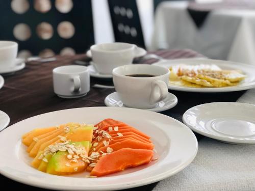 una mesa con platos de comida y una taza de café en AOHOM SANTUARIO HOTEL & SPA, en Jiutepec