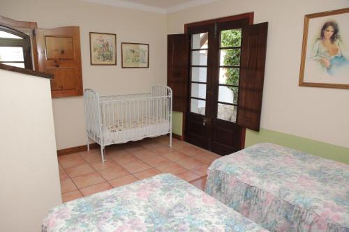 a room with two beds and a crib in it at Quinta de Rio Alcaide in Porto de Mós