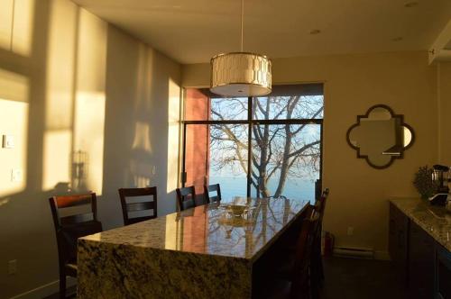 a kitchen with a table with chairs and a large window at Driftwood Inn in Sechelt