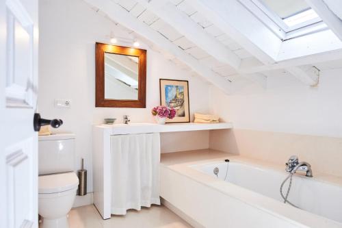 a bathroom with a tub and a toilet and a mirror at La Tudanca in Sobremazas