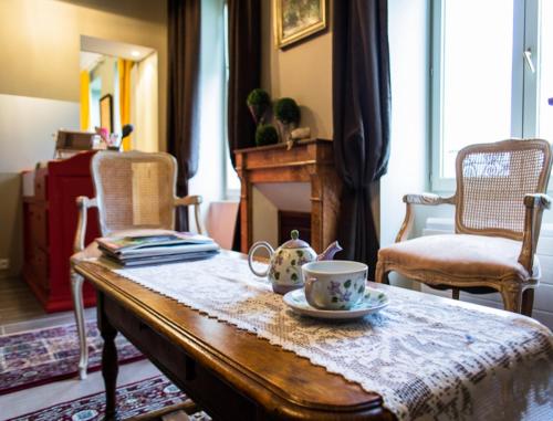 une table avec une tasse de thé dessus dans l'établissement Gites Chateau Comblanchien, à Comblanchien
