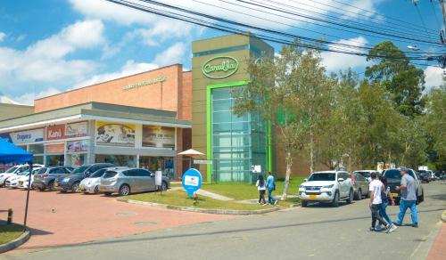 a group of people walking in front of a car dealership at Llanogrande Airport by Bernalo Hotels in Rionegro
